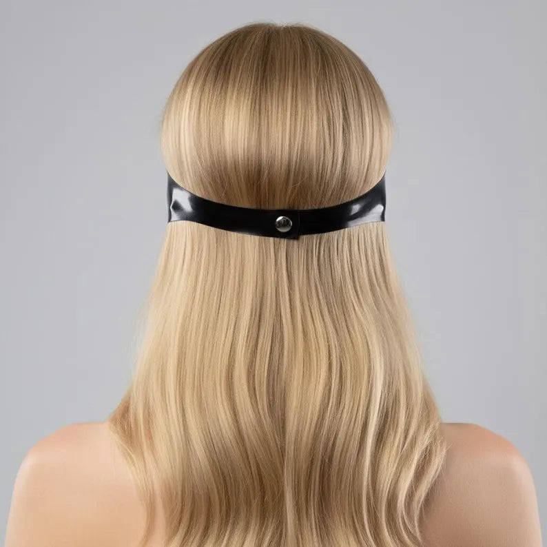 Close-up of the back of the head showing the metallic snap button closure on a latex blindfold.