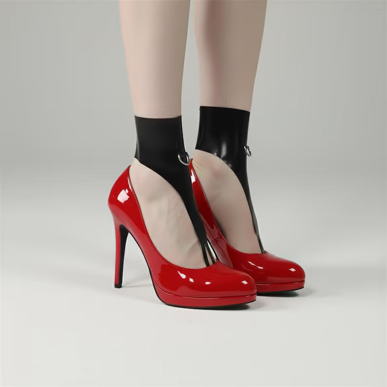 Latex foot harness accessorized with red high heels, showcasing a high-shine fetish and avant-garde fashion look.