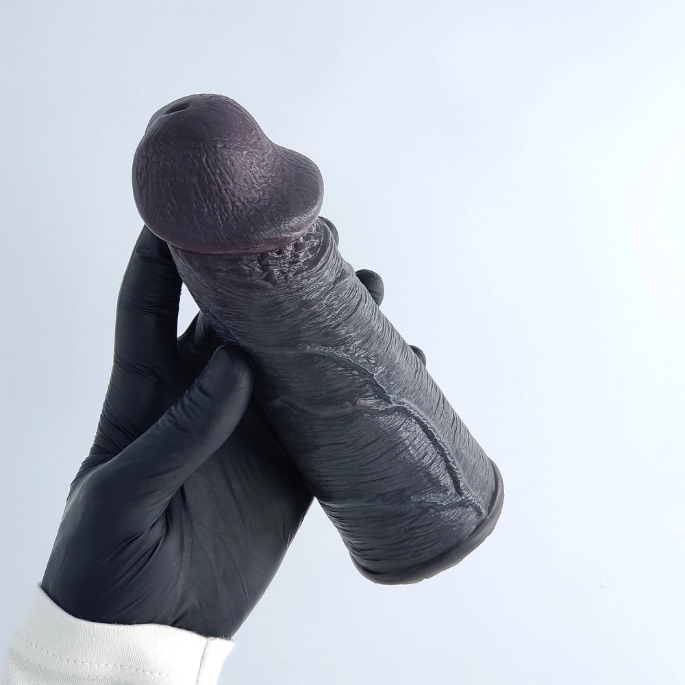 Hand in a black glove holding the Mega Veins Black sleeve, showing scale and sleek aesthetic.