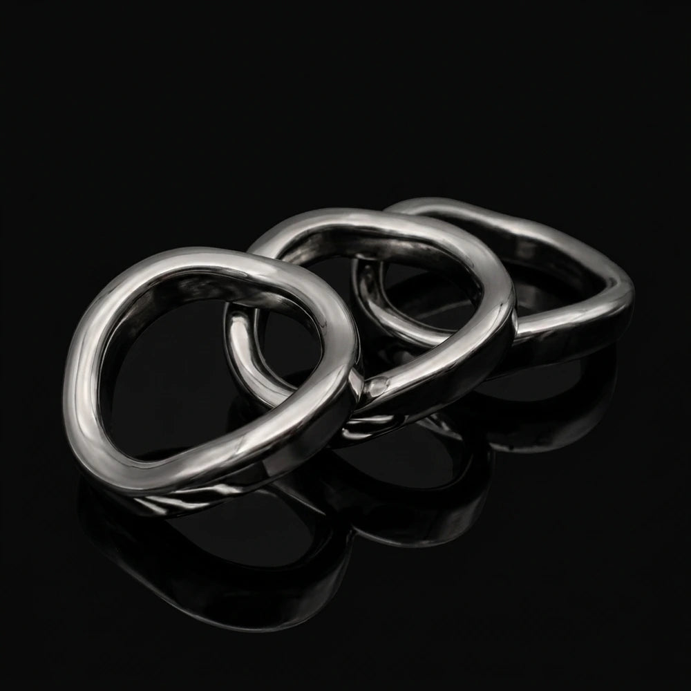 Three Stainless Steel Contoured Cock Rings displayed on a black reflective surface