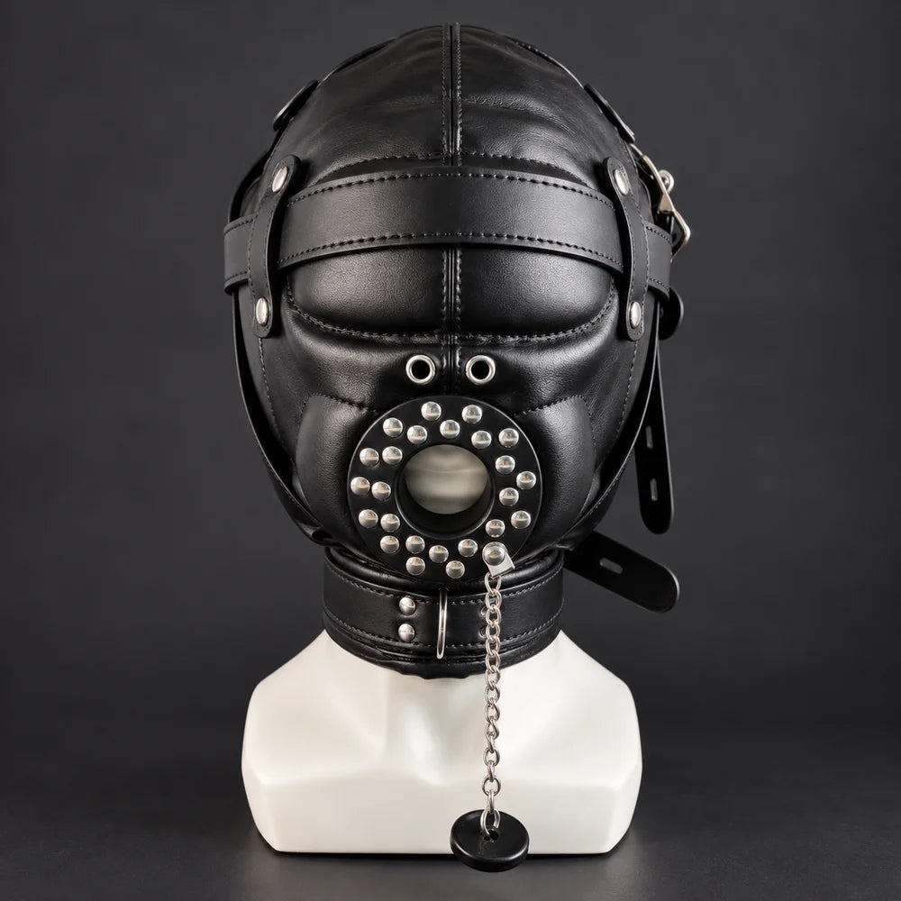 Black leather bondage hood with covered eyes, studded mouth cover, silver metal chains and adjustable straps, displayed on a white mannequin, front view.