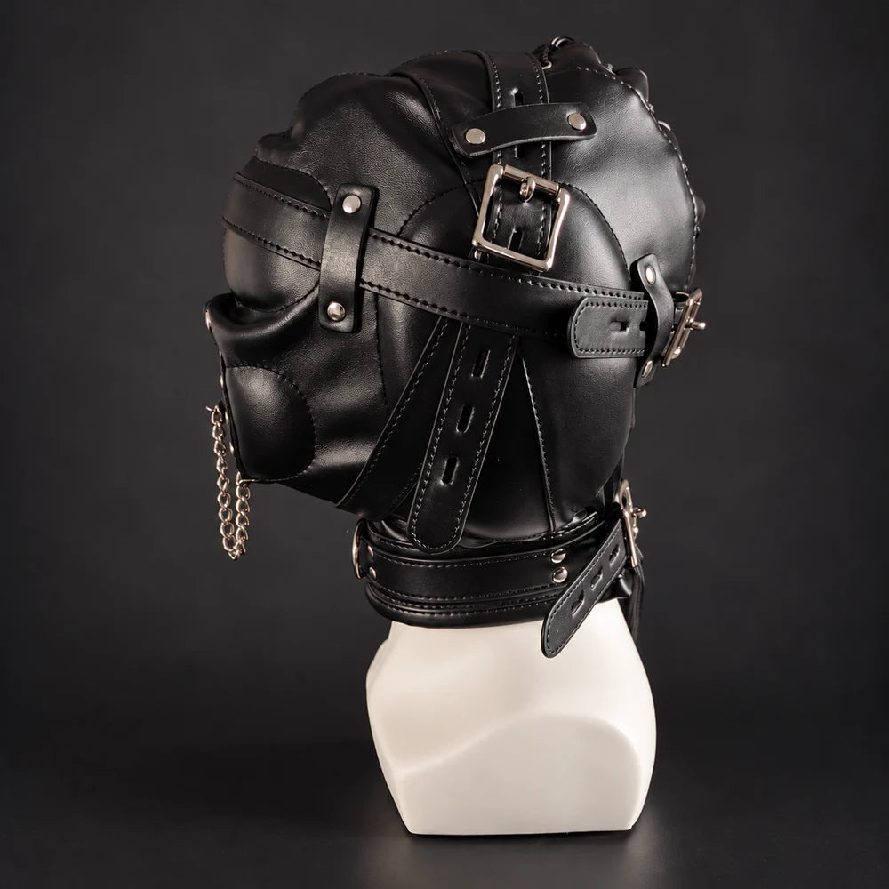 Black leather bondage hood with adjustable buckle straps, silver metal hardware and padded panels, displayed on a white mannequin in rear three-quarter side view