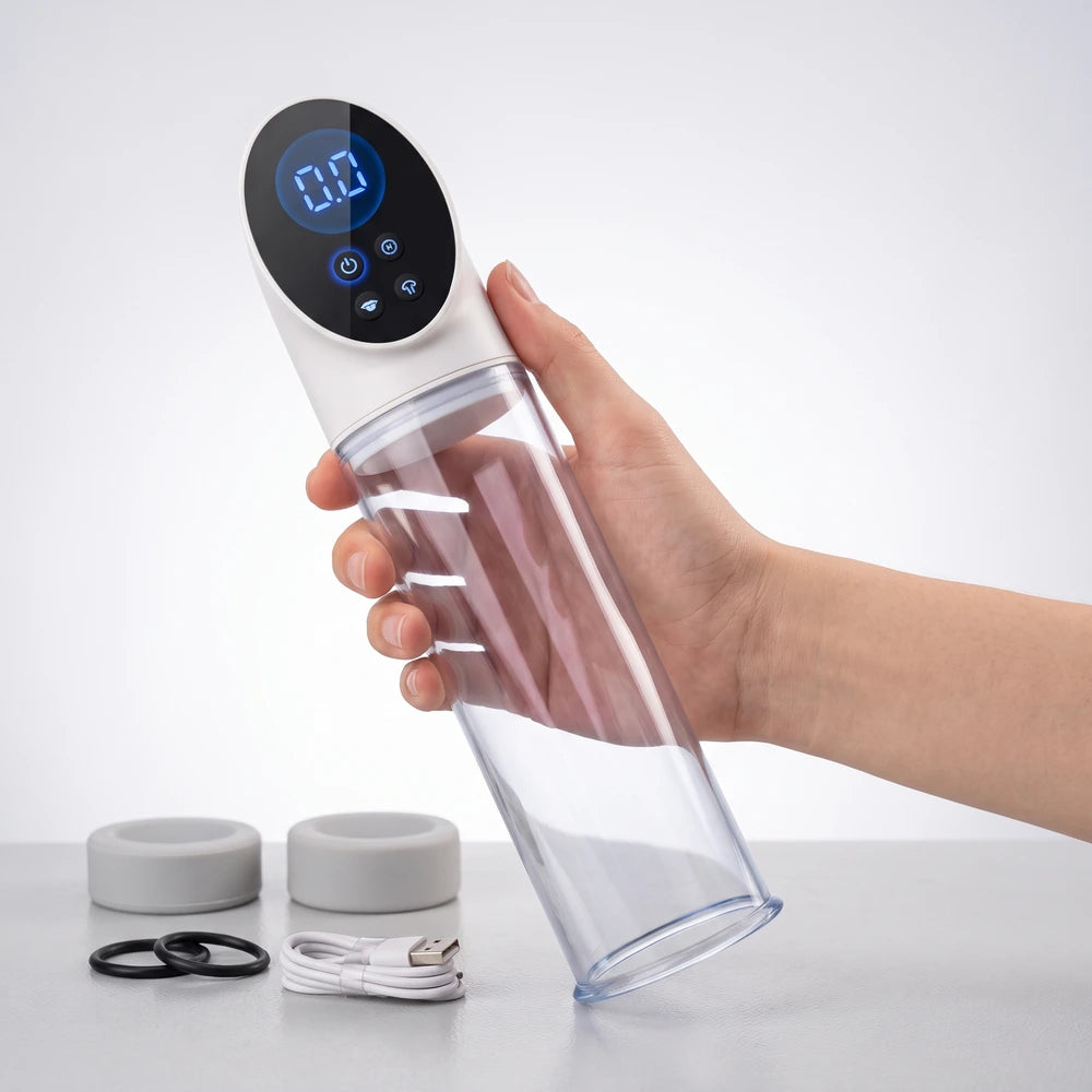 Hand holding the electric vacuum pump for ED, with interchangeable silicone sleeves and accessories in the background.
