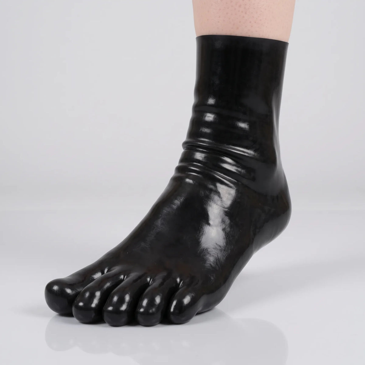 Black short latex toe sock with five separate toes, front close-up on a light grey background