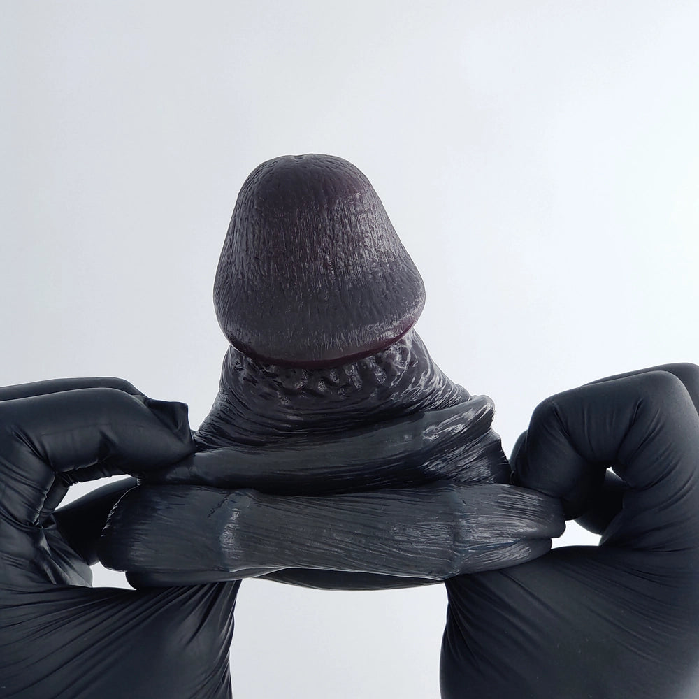 Mega Veins Black silicone sleeve coiled to demonstrate its flexibility, softness, and material quality.