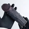 Person wearing black gloves holding realistic black penis sleeve perfect cut front view