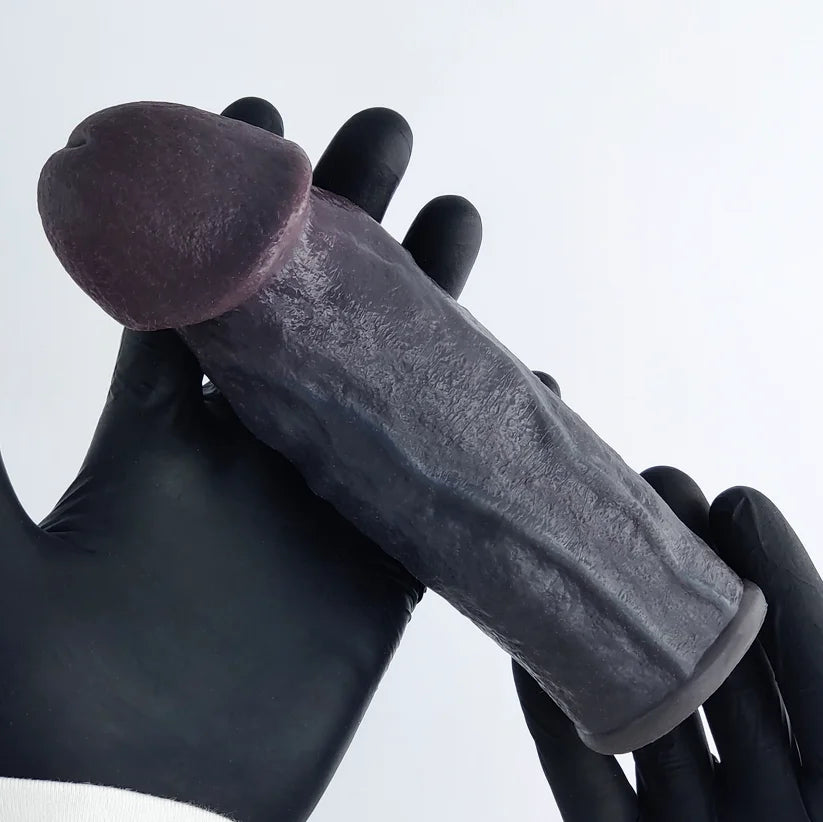 Person wearing black gloves holding realistic black penis sleeve perfect cut front view