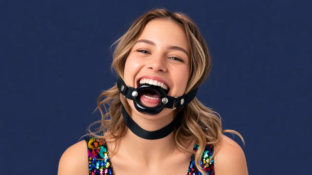 Smiling woman wearing a black O-ring mouth spreader gag