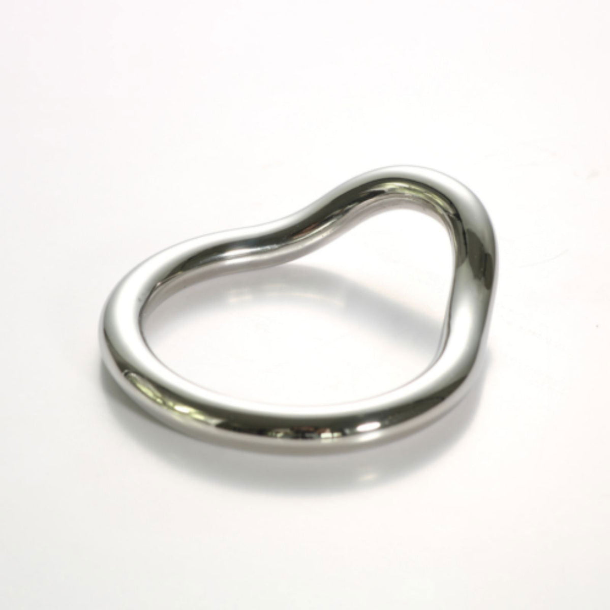Stainless steel curved cock ring, three-quarter view on a white background
